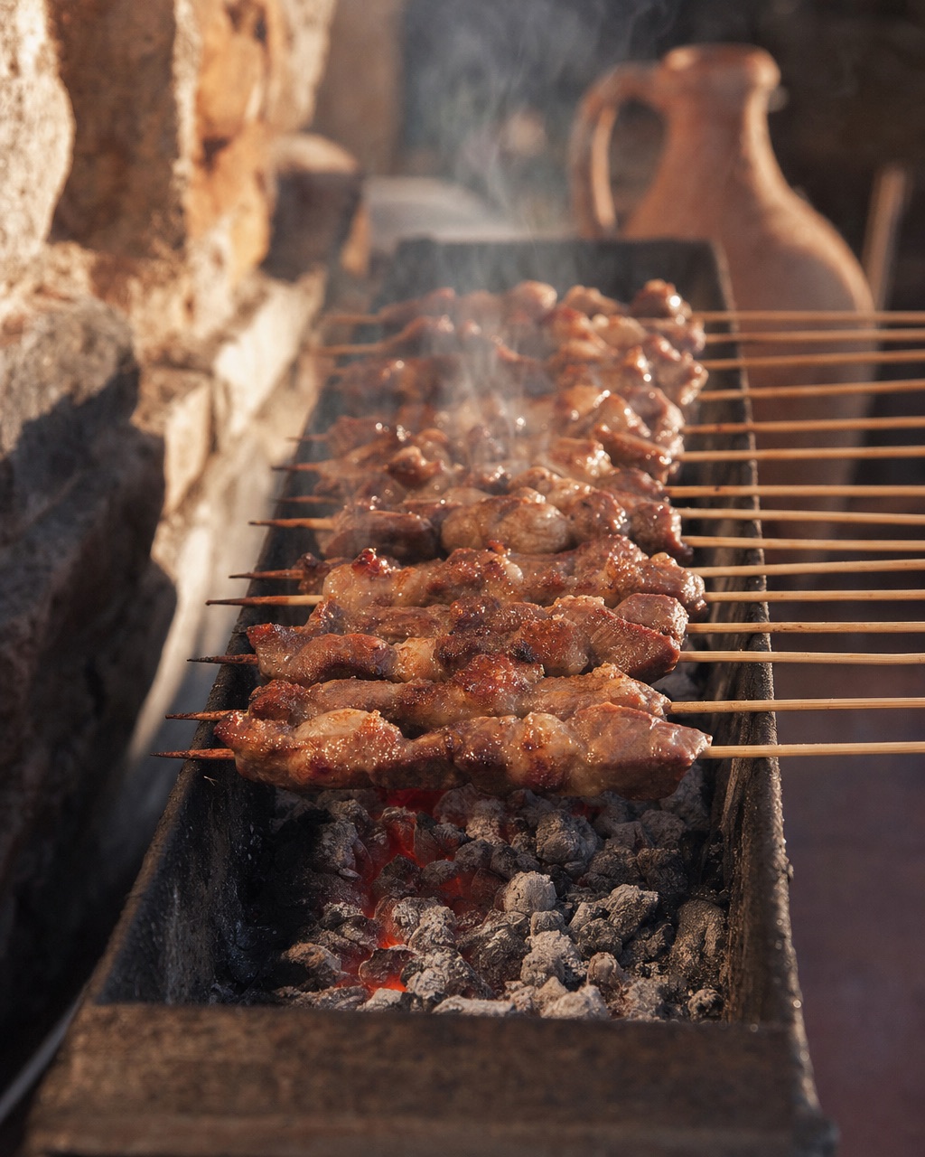 Arrosticini pronti su griglia tradizionale con fuoco vivo sotto