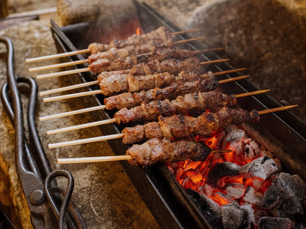 Arrosticini abruzzesi su griglia di metallo con brace